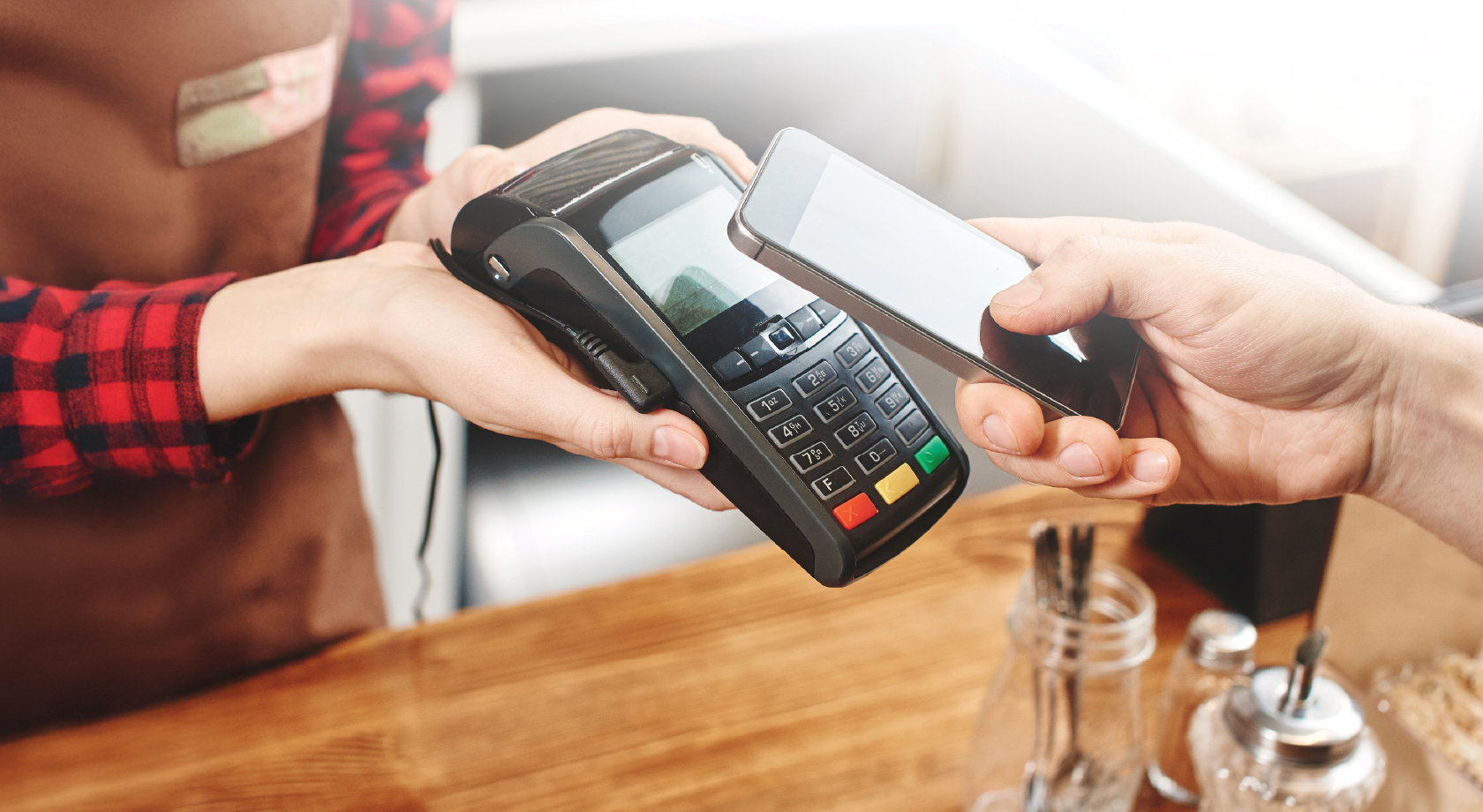 Image of hand paying with mobile wallet at local business.