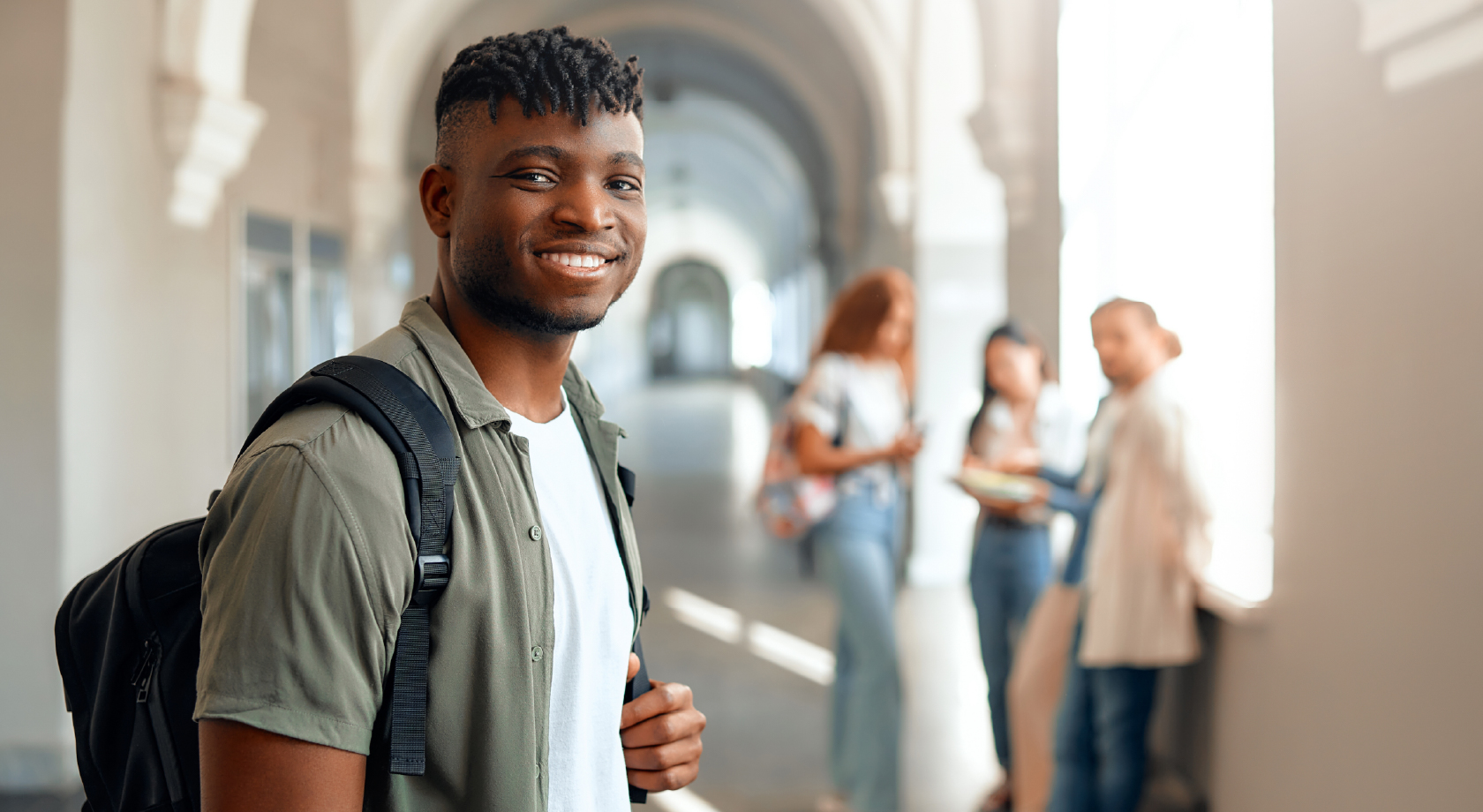 Student looking and smiling with others in the background.